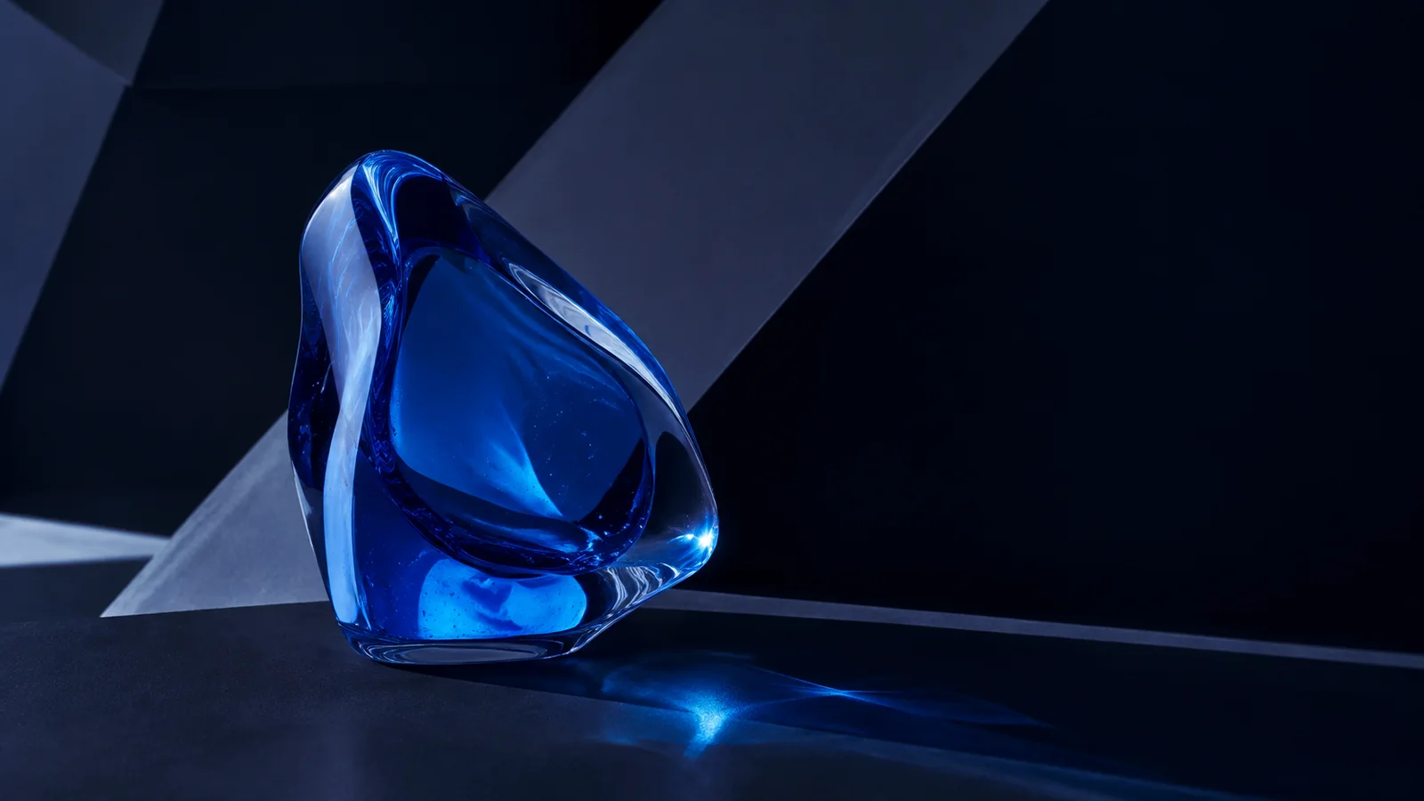 Composition abstraite d’un objet de verre bleu dans une lumière sombre